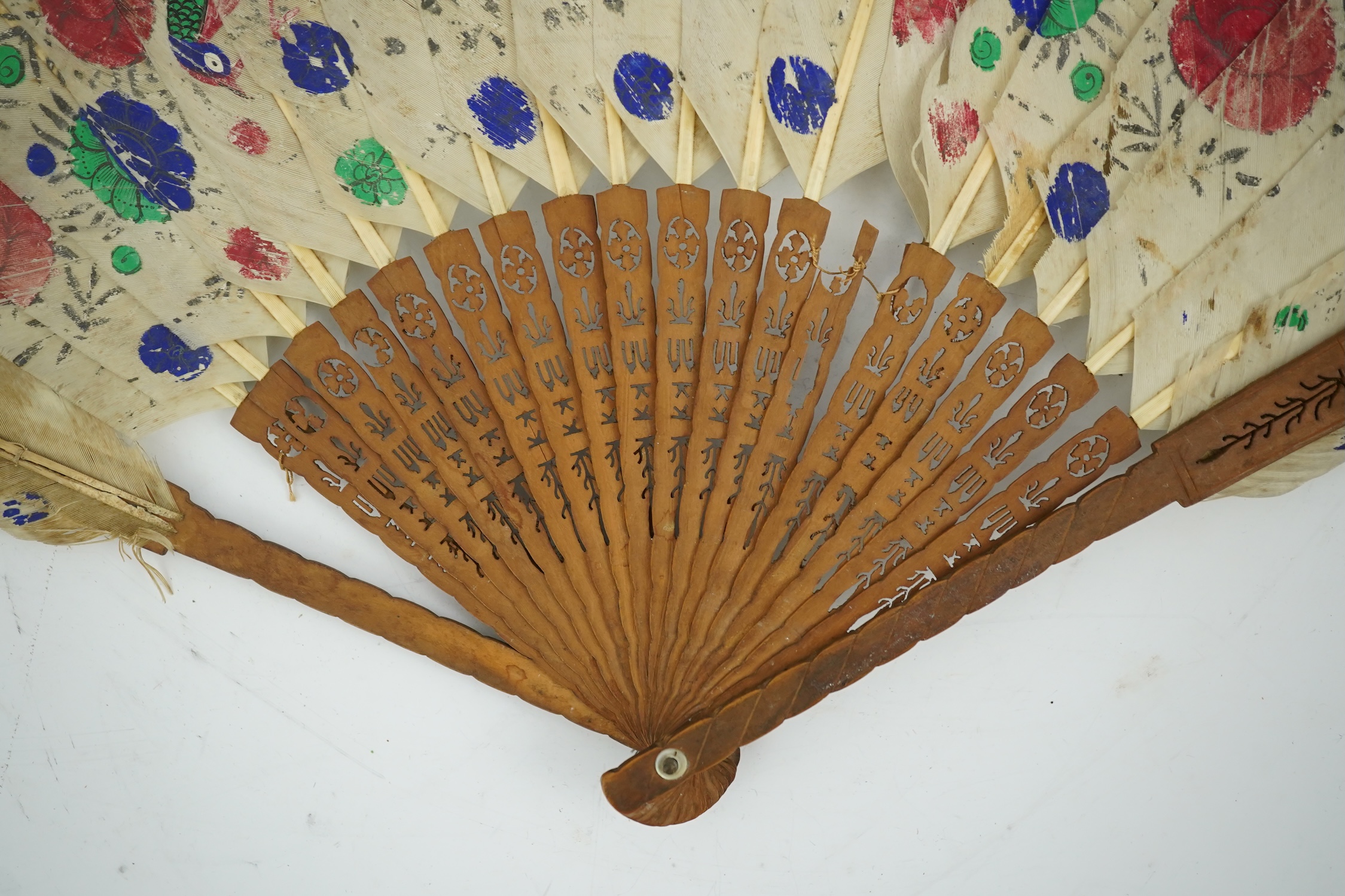 Three 19th century Chinese feather fans: One a carved bone brise black feather fan together with two similar carved sandalwood feather fans, two fans have hand painted decoration on the feathers both sides, the pink feat